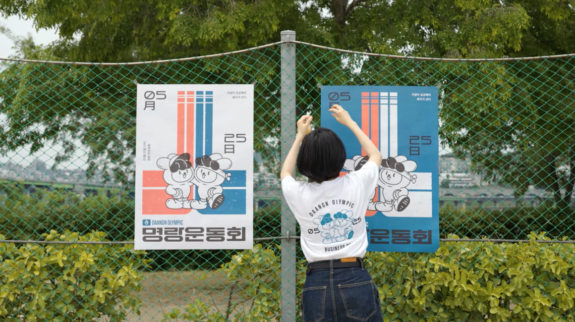 당근마켓 명랑운동회 포스터를 벽에 붙이고 있어요